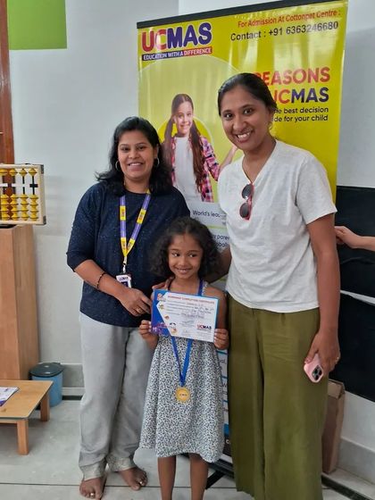 Another happy graduate of our UCMAS Abacus program, proudly holding her certificate with her parent and teacher.