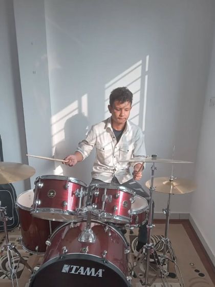 A student practicing on the drums. Our facility is equipped with quality instruments for our students to learn on.