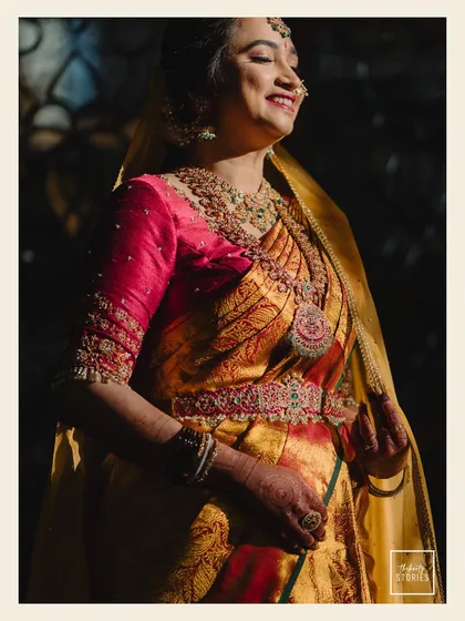 A joyful bridal portrait, with the bride basking in a ray of sunlight. Her happy expression and the beautiful details of her saree and jewelry are perfectly captured.