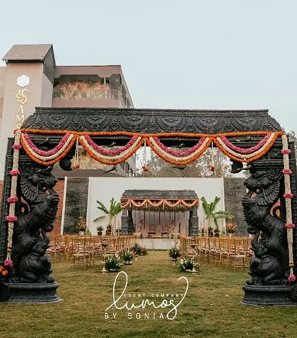 A wide-angle shot of a temple-style wedding entrance and mandap. The grand scale and traditional architectural elements create an awe-inspiring first impression.