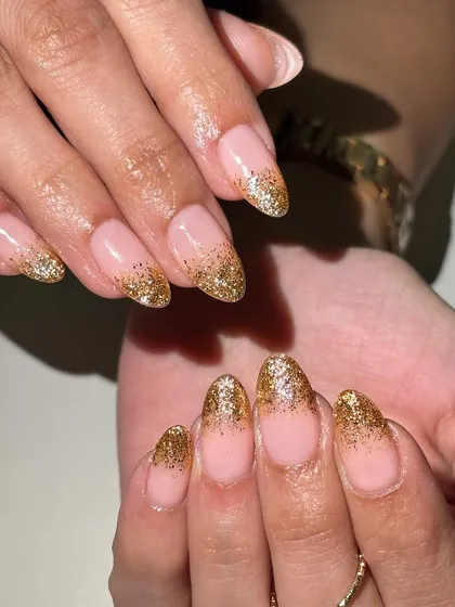 A classic choice for the wedding season. This elegant design features a nude base with a sparkling gold glitter fade, perfect for a glamorous look.