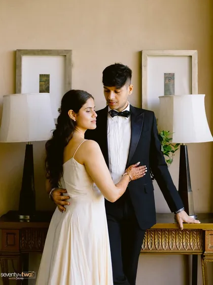 The epitome of classic elegance. Dressed in a timeless tuxedo and a beautiful white gown, they share a quiet, romantic moment. A perfect, formal pre-wedding portrait.