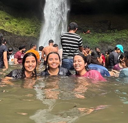 Three friends having a great time in the cool waters of Devkund Waterfall.