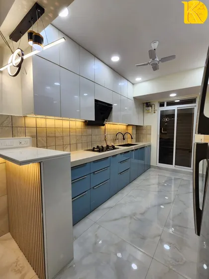 This wide-angle shot captures the entire kitchen, including the breakfast counter and modern pendant lights, showcasing a complete kitchen solution.