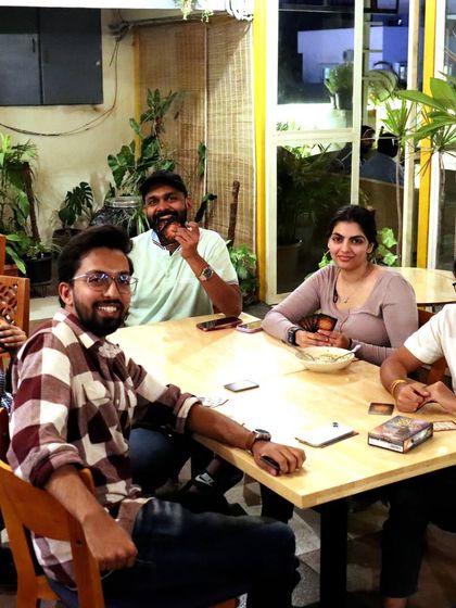 A group of friends enjoying a card game on a Saturday evening. The relaxed atmosphere of the terrace is perfect for unwinding after a long week.