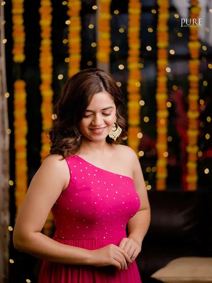 Another stunning portrait of the bride at her Mehndi party, with a backdrop of marigold strings adding a traditional, festive touch.