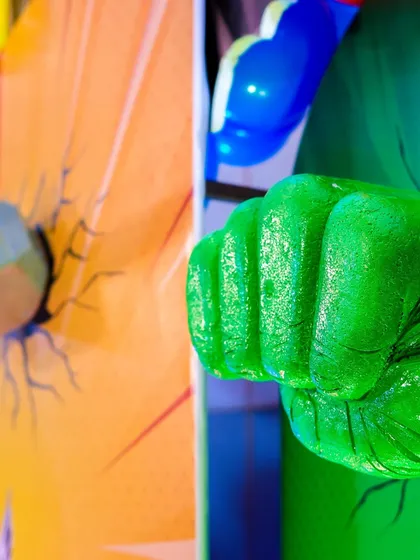 A detailed shot of the Hulk's fist prop, appearing to smash through a wall, adding a dynamic and exciting element to the decor.