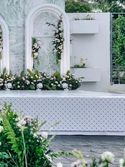 Our stage designs consider the entire environment. Here, integrated planters and clean white architectural details blend seamlessly with the surrounding greenery, creating a cohesive and elegant look.