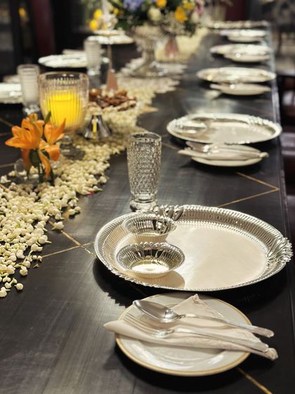 A beautifully arranged table setting featuring elegant silverware and floral decorations for the Karvachauth episode of 'Fabulous Lives of Bollywood Wives'. This showcases our experience in catering for high profile, televised events where presentation is paramount.