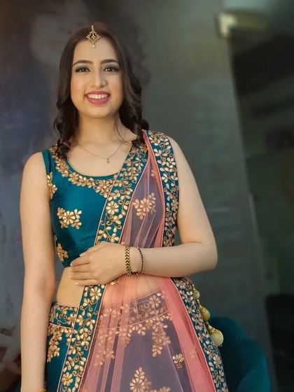 This client is ready for a party in her teal and pink lehenga. The makeup is kept fresh and radiant with a simple maang tikka and braided details in her hair.