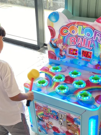 A young guest tries his luck at the "Color Ball" whack-a-mole style arcade game.