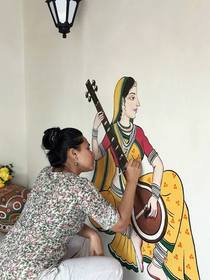 I love getting lost in the details of traditional Indian art. This is a close-up of me painting a musician figure, inspired by the delicate lines of Pichwai and Madhubani styles, for a resort wall in the Konkan region.