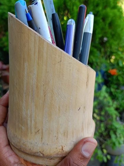 A beautifully crafted bamboo pen holder, shown in a natural setting. This functional and sustainable desk accessory is a simple way to bring a touch of nature to your office while staying organized.