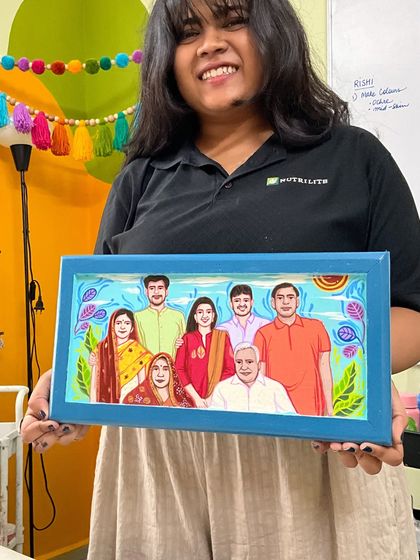 My team member, Rishi, proudly holding a completed family portrait board. It's always a team effort to bring these large, detailed pieces to life.