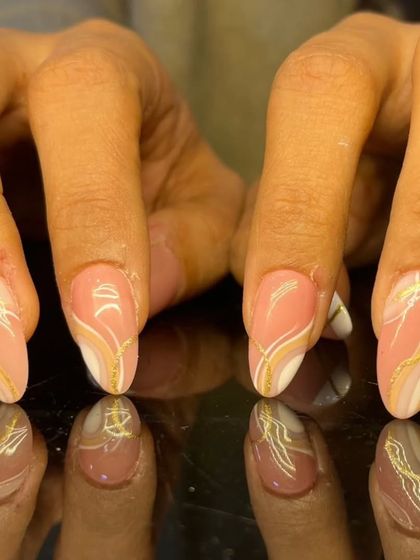 A beautiful and elegant design with pink, white, and gold marble-like swirls on almond-shaped nails.