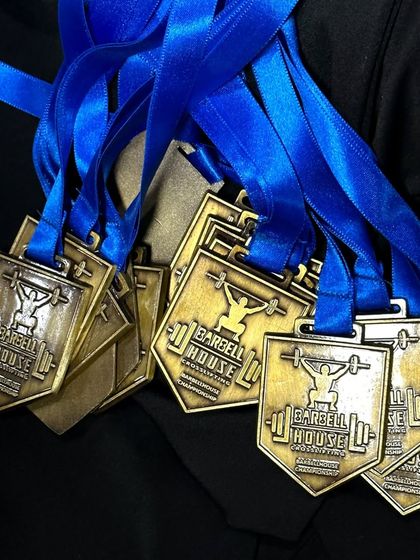 A closer look at the medals awarded at our championship. Every lifter who steps on the platform is a winner in our eyes.