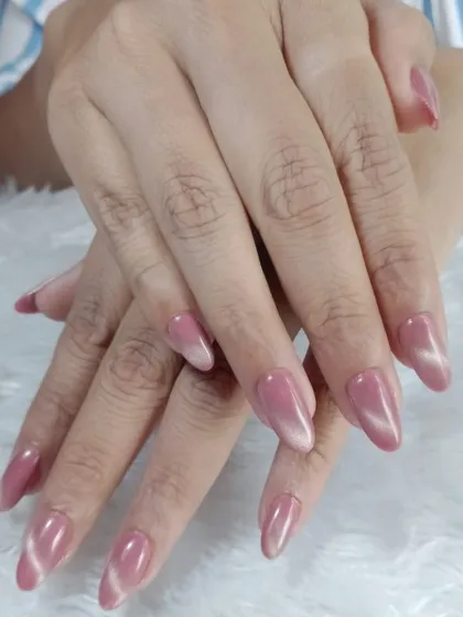 A subtle and sophisticated pink cat-eye effect on almond-shaped nails, creating a soft, velvety shimmer.
