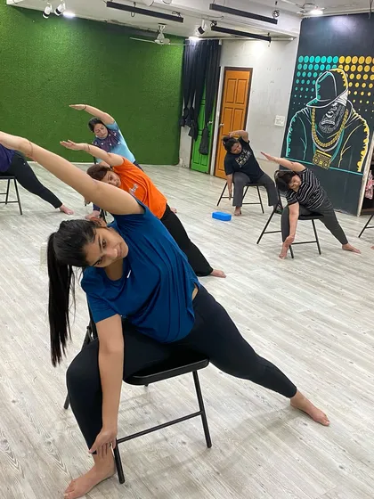 The entire class moving in unison during a seated side stretch.