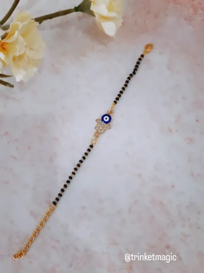 This design combines two powerful symbols: the Hamsa hand and the evil eye. It's a beautiful and meaningful piece, set on a classic mangalsutra-style bracelet.