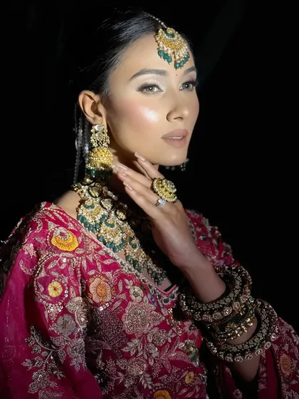 A dramatic shot highlighting the model's sharp features, enhanced with contouring and a powerful highlighter. This is an example of the editorial-style bridal looks we teach.
