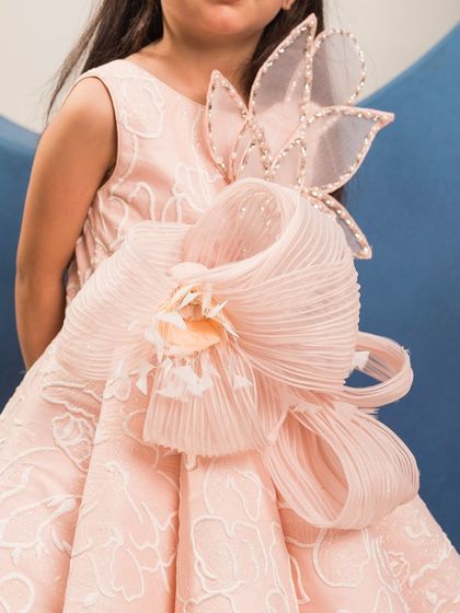 A close up of the exquisite, handcrafted bow that is the centerpiece of this elegant pink gown.