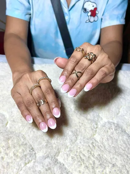 A classic French manicure on short, natural-looking nails. This shows that extensions can be used to create a very subtle and clean look.
