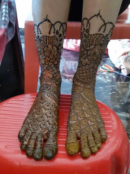 This traditional foot design includes a beautiful scalloped border at the ankle and dense patterns covering the rest of the foot.