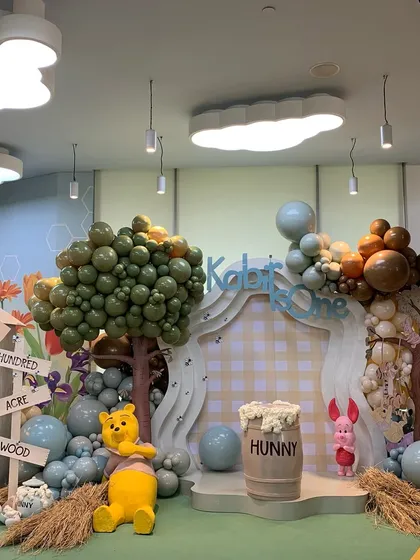 I brought the classic story of Winnie the Pooh to life for Kabir's first birthday. This view of the Hundred Acre Wood setup shows how I use custom props, themed backdrops, and creative balloon sculptures to build a nostalgic and heartwarming world.