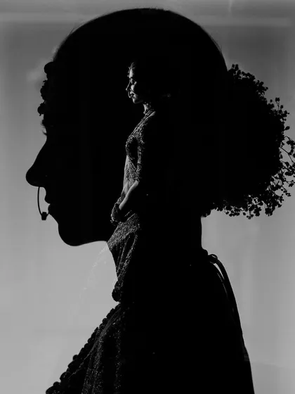 An artistic black and white double exposure, creating a complex and beautiful silhouette portrait of the bride.