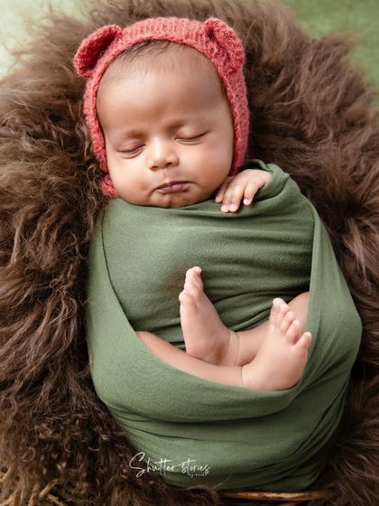 A close-up focusing on the baby's sweet, sleeping face and the texture of the green wrap.