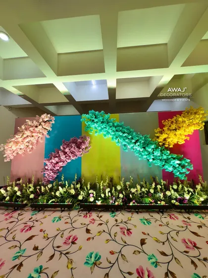 A pastel-themed photo wall with colorful bursts of flowers against a multi-hued backdrop.