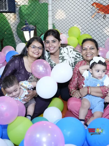 Three generations of family enjoying the party together in the ball pit. It's a celebration for everyone.