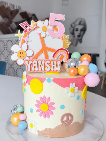 We love a fun theme, and this retro groovy cake topper was a joy to create for Yanshi's 5th birthday. The vibrant colors and cheerful icons like smiley-face daisies and peace signs perfectly capture that fun, throwback vibe.
