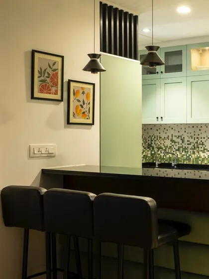 Another view of the peninsula, showing how it divides the space while keeping it open and connected. The pendant lights define the dining area, and the framed art adds a personal touch.