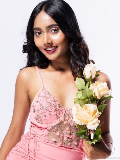 A smiling portrait of the model with roses.
