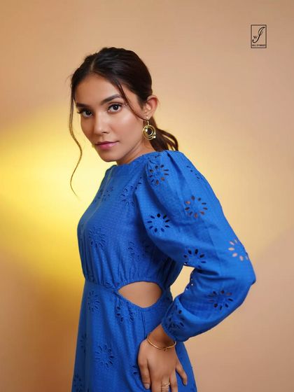 A close-up portrait showcasing a blue dress with intricate cutout details, perfect for a brand's product feature.