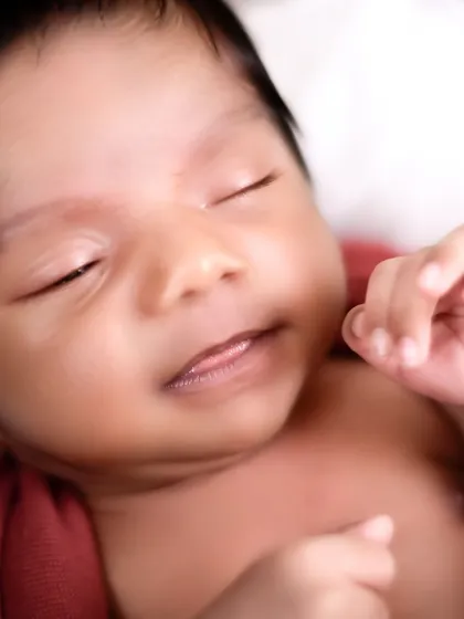 A close-up shot focusing on the pure, sleeping face of a newborn. These macro shots capture the details you'll want to remember forever, like their tiny lips and soft skin.