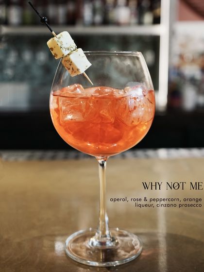 Why Not Me? A playful and effervescent spritz from our Valentine's menu, featuring Aperol, rose & peppercorn liqueur, and prosecco, garnished with paneer.