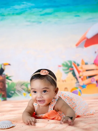 A happy beach baby crawling towards the shore. The bright, cheerful colors of this setup are perfect for a milestone celebration.