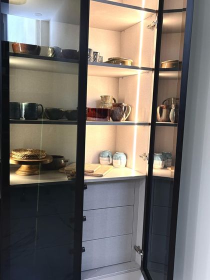 This view highlights the vertical LED strip lighting inside the crockery cabinet. This feature not only illuminates your dinnerware but also adds a warm, ambient glow to the room, turning storage into a display.