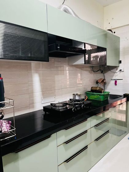 A slightly different angle of the sage green kitchen, showing the efficient layout and ample storage provided by both upper and lower cabinets.