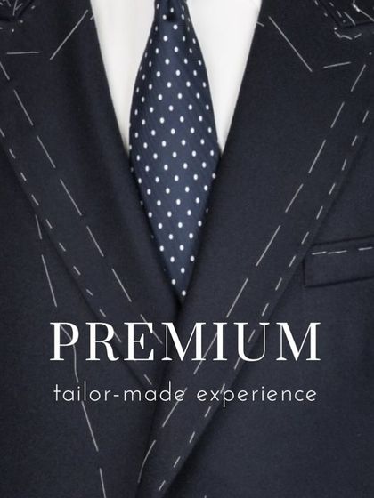 A close-up of a suit jacket being tailored, showing the temporary basting stitches. This is part of the premium, tailor-made experience I promise every client.