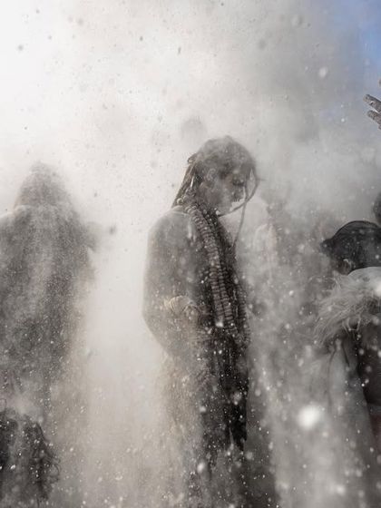 A slightly different angle of the Masan Holi celebration, capturing the dynamic interactions between participants as they are covered in ash.