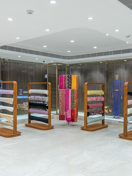 Freestanding display units on the third floor showcase unstitched fabrics. These custom fixtures allow for flexible merchandising, with options for both hanging and stacking materials.
