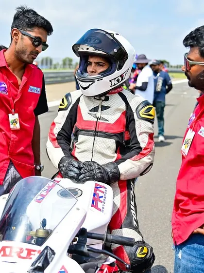 This is what our support looks like. Here, we're giving rider Meghana a pre-race briefing at her national debut in the INMRC. We provide full technical and motivational support to every rider, ensuring they are prepared and confident on the grid.