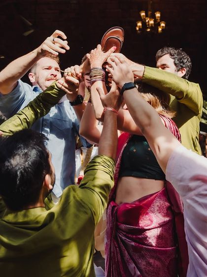 A fun and playful moment from the 'joota chupai' ritual, where the bride's side playfully steals the groom's shoes.