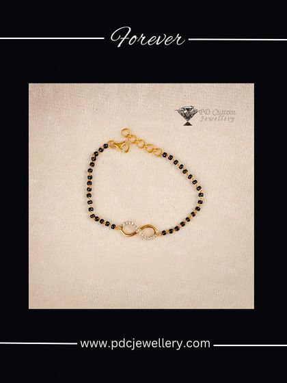 A modern take on tradition, this is a "Hand Mangalsutra" or bracelet. It features the symbolic black beads with a delicate diamond infinity charm, perfect for everyday wear.