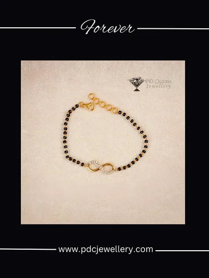 A modern take on a traditional symbol. This "Hand Mangalsutra" is a delicate bracelet featuring the classic black beads and an infinity-symbol diamond charm, perfect for the modern woman.