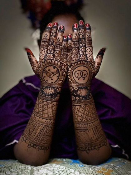 A creative design with a clock showing a special time on one palm and the couple's initials, 'SR', on the other.