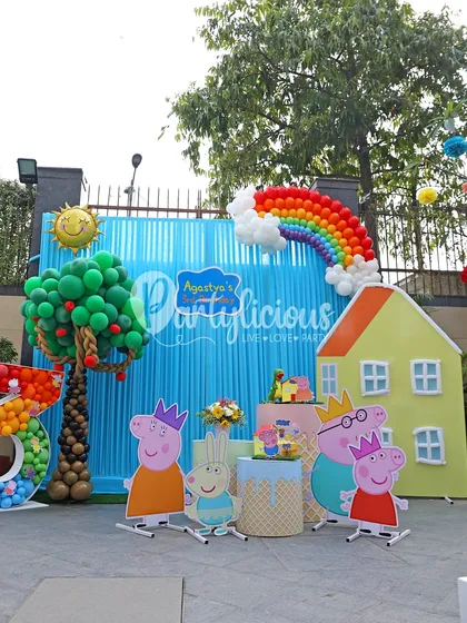 An oink-tastic Peppa Pig party! We recreated Peppa's world with character cutouts, her iconic house, a balloon rainbow, and a tree, all set against a bright blue backdrop for a picture-perfect scene.
